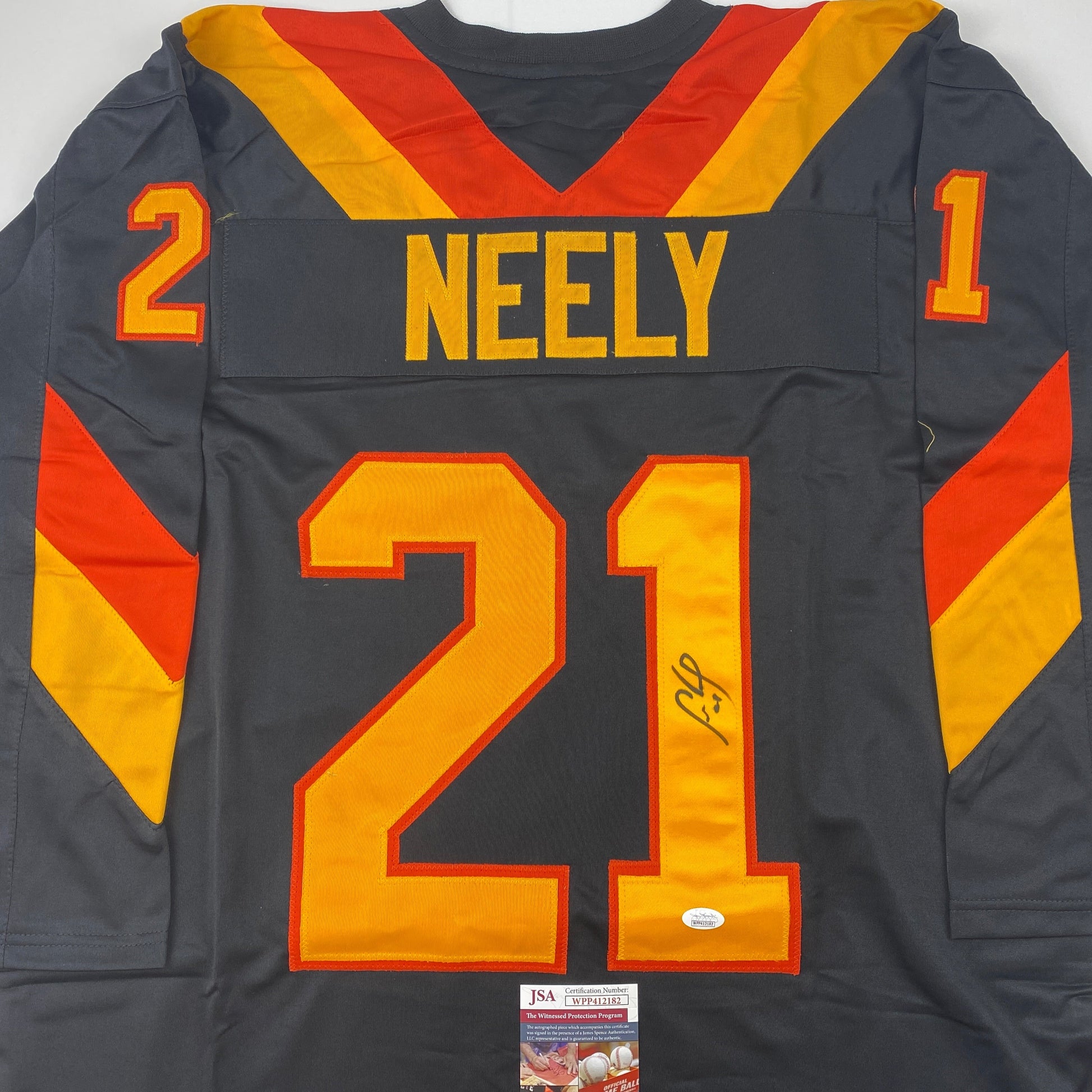 Back view of black hockey jersey with yellow and red diagonal stripes, "NEELY" and number 21 in yellow with red outline, JSA authentication label visible at bottom.