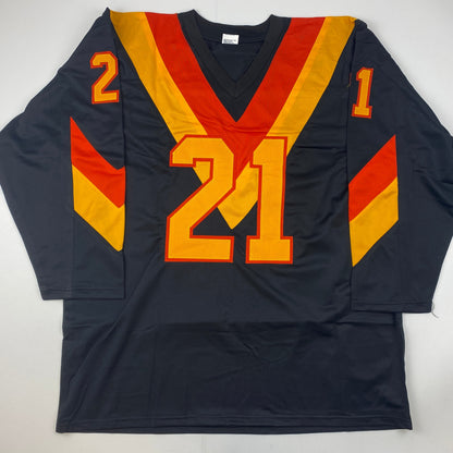 Black hockey jersey with gold and red trim displaying large yellow number 21 with red outline, smaller numbers 2 and 1 on sleeves, laid flat against white background.