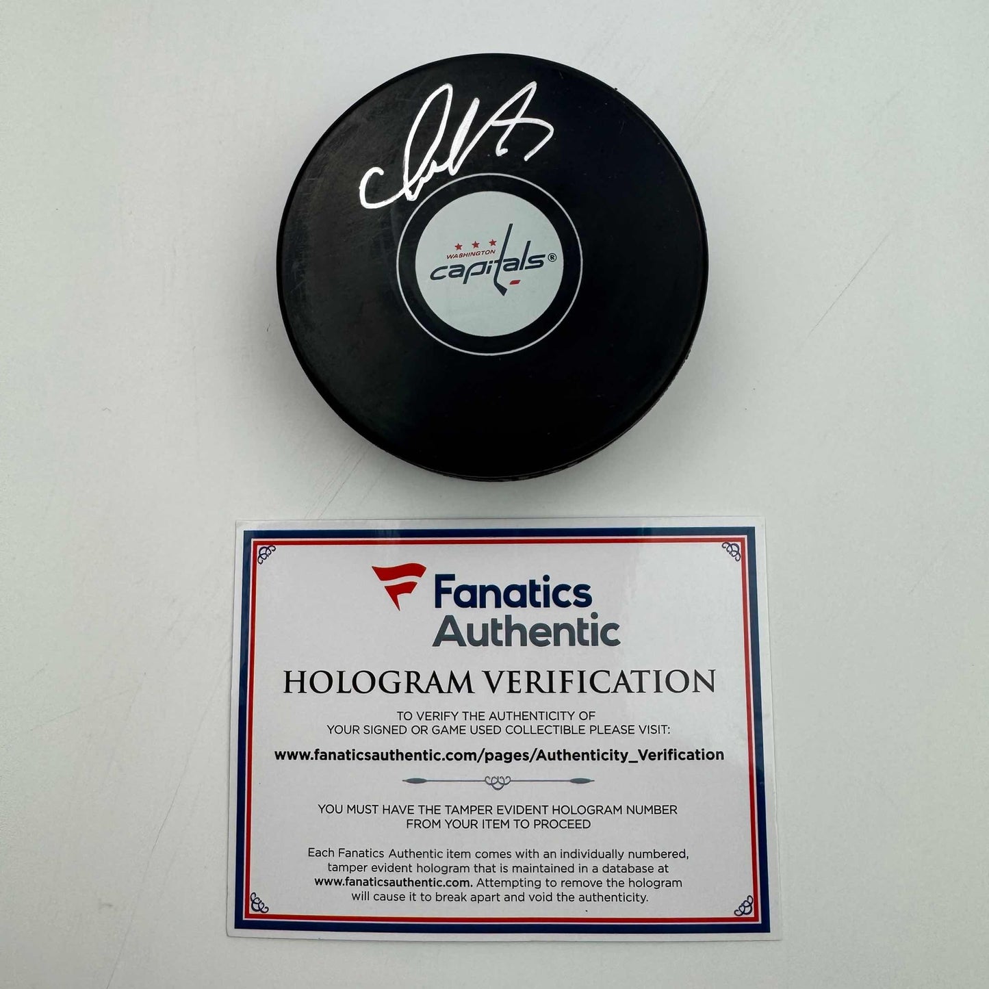 Signed black hockey puck with Washington Capitals logo and Fanatics Authentic hologram verification certificate displayed below.