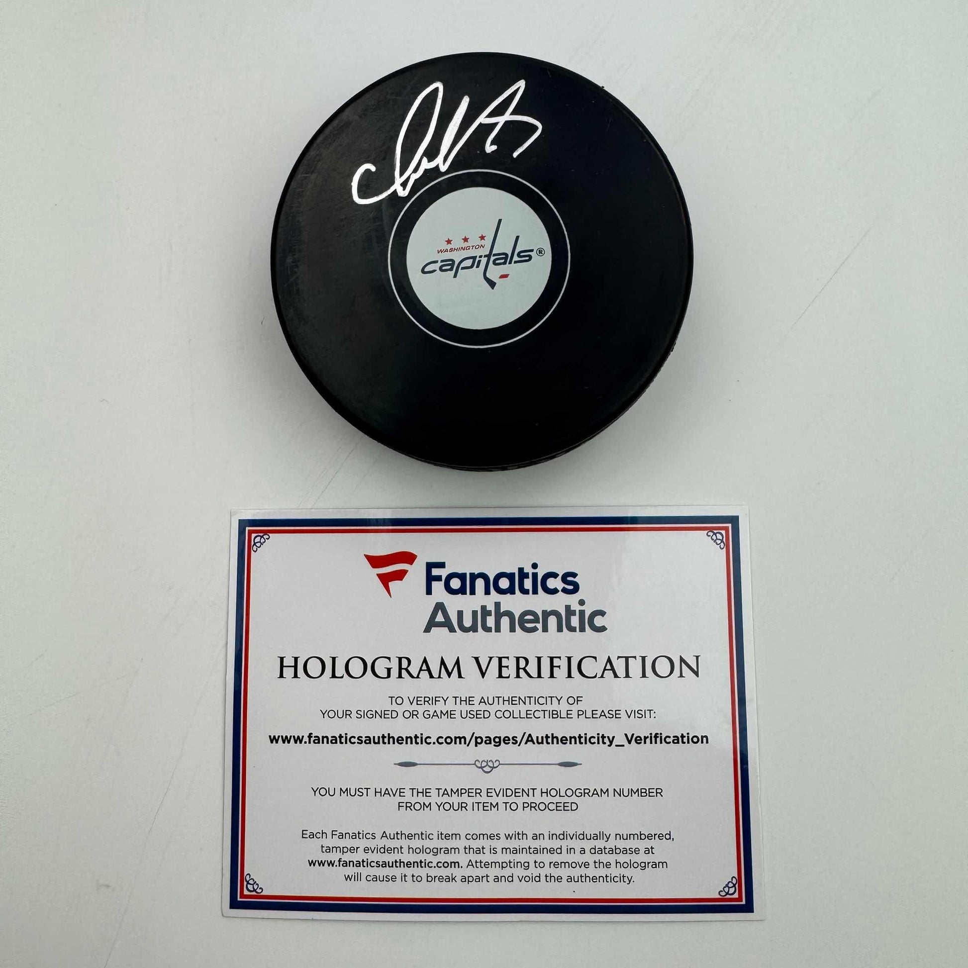 Signed black hockey puck with Washington Capitals logo and Fanatics Authentic hologram verification certificate displayed below.