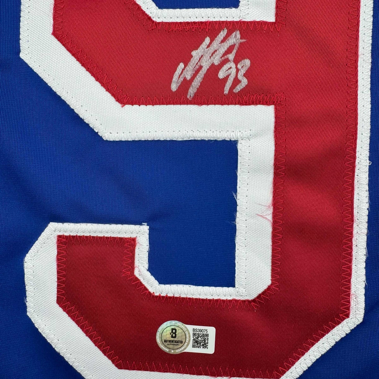 Close-up of signed blue and red hockey jersey number 93 with Beckett authentication hologram sticker visible at bottom.