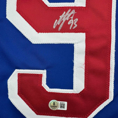Close-up of signed blue and red hockey jersey number 93 with Beckett authentication hologram sticker visible at bottom.