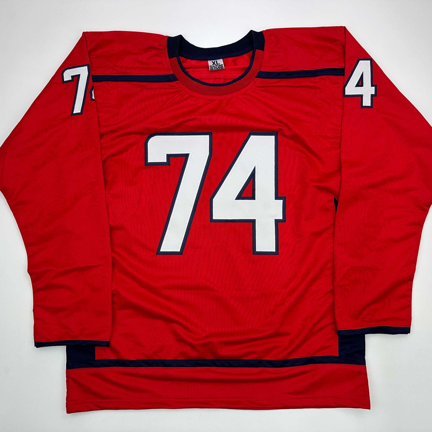 Red hockey jersey with white and navy number 74 on chest, displayed flat against white background showing front view.
