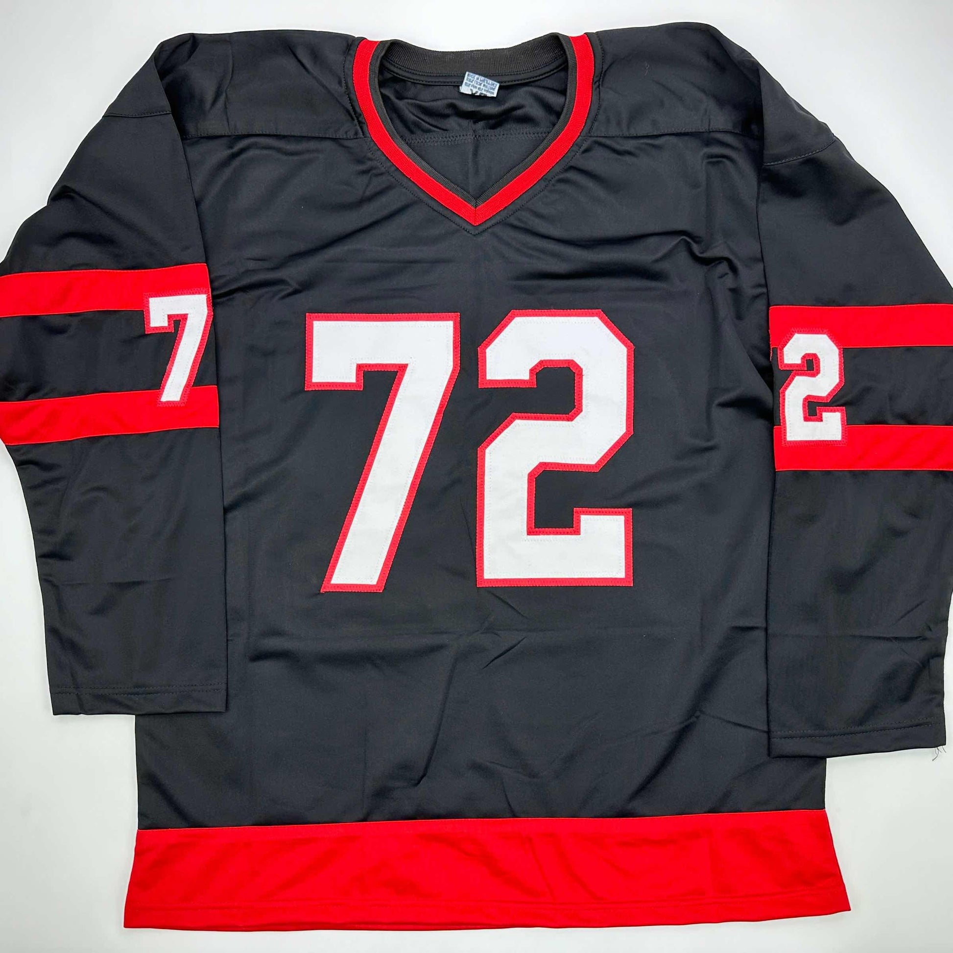 Black and red hockey jersey with white number 72 displayed flat against white background, showing front view with V-neckline and red horizontal stripes on sleeves and hem.