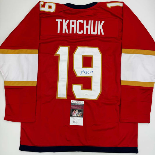 Red Florida Panthers hockey jersey #19 TKACHUK displayed flat, back view showing name and number with JSA authentication label.