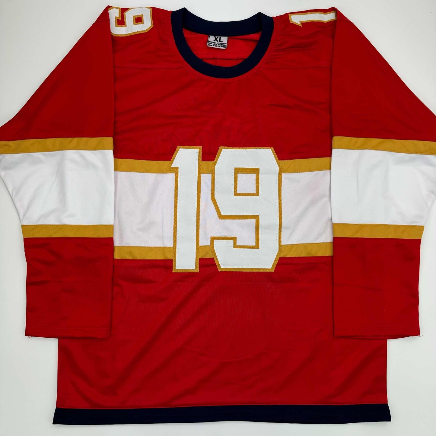 Red and white hockey jersey with gold trim and number 19 displayed flat against white background, front view.