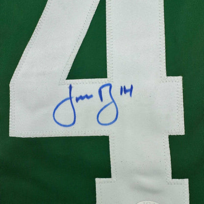 Close-up of blue handwritten signature on white fabric strip of green retro hockey jersey.