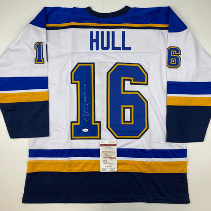 Signed white St. Louis Blues hockey jersey number 16 with Hull nameplate, displayed flat with JSA authentication certificate visible.