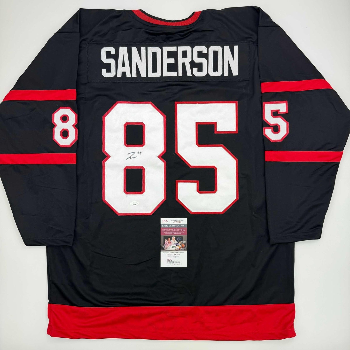 Back view of black and red Ottawa Senators hockey jersey #85 with "SANDERSON" nameplate and JSA authentication certificate visible.