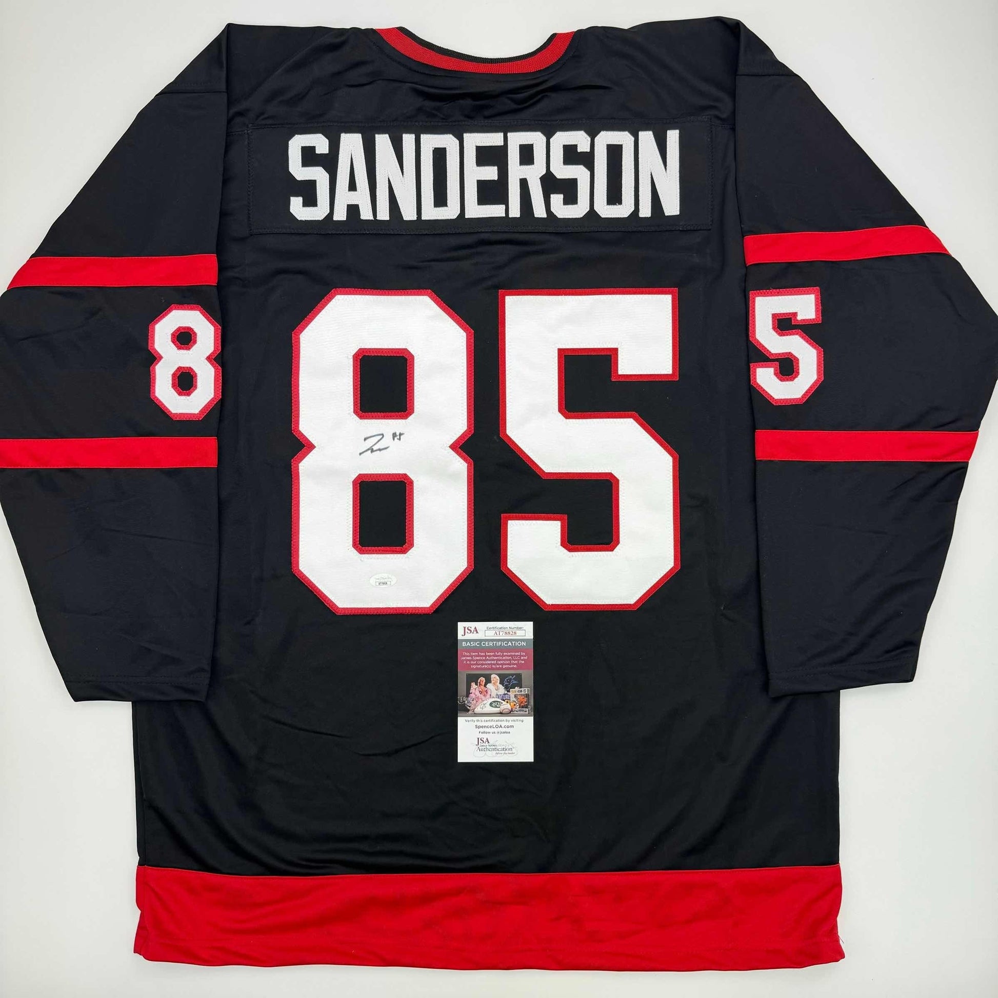 Back view of black and red Ottawa Senators hockey jersey #85 with "SANDERSON" nameplate and JSA authentication certificate visible.