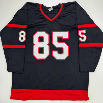 Black hockey jersey with red and white number 85 and red horizontal stripes, displayed flat against white background.