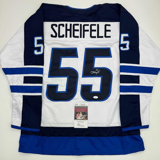 Reverse view of white Winnipeg Jets hockey jersey number 55 with "SCHEIFELE" nameplate and JSA authentication certificate attached.