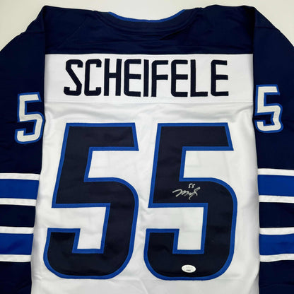 Back view of white hockey jersey with navy sleeves, large navy number 55, blue-outlined numerals, "SCHEIFELE" nameplate, and visible signature on front.