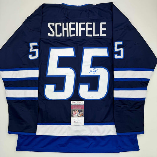 Back view of navy blue Winnipeg Jets hockey jersey number 55 with "SCHEIFELE" nameplate and JSA authentication certificate.