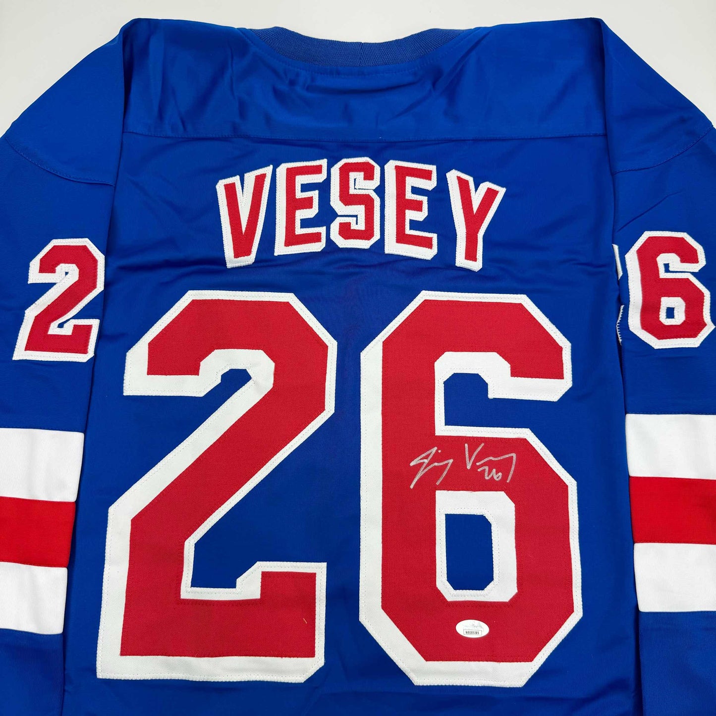 Blue hockey jersey displaying "VESEY" and number 26 in red and white, with autographed signature visible on the number.
