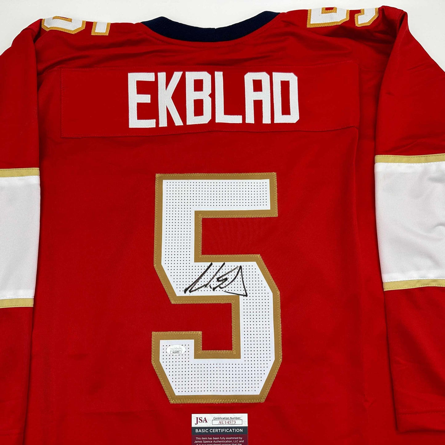 Red hockey jersey back displaying "EKBLAD" nameplate, number 5 with signature, and JSA authentication label.