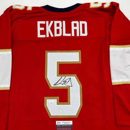 Red hockey jersey back displaying "EKBLAD" nameplate, number 5 with signature, and JSA authentication label.