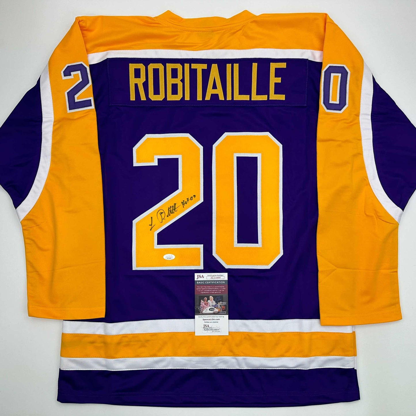 Back view of purple and gold LA Kings hockey jersey number 20 with "ROBITAILLE" nameplate and JSA authentication certificate.