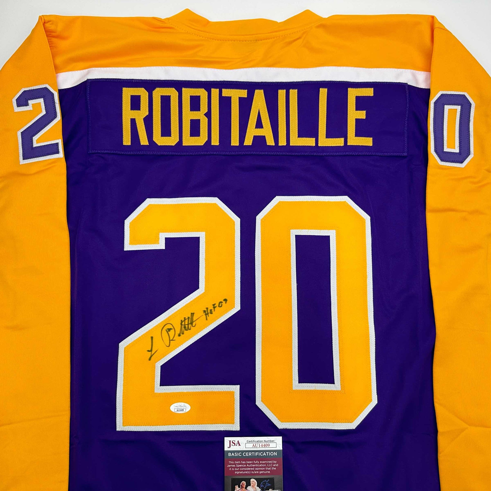 Back view of purple and gold hockey jersey with "ROBITAILLE" and number 20 in yellow with autograph and JSA certification sticker.