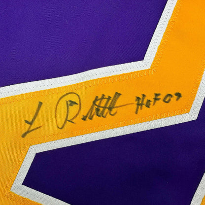 Close-up of signed yellow stripe on purple and gold hockey jersey showing "Luc Robitaille HOF 09" autograph in black ink.