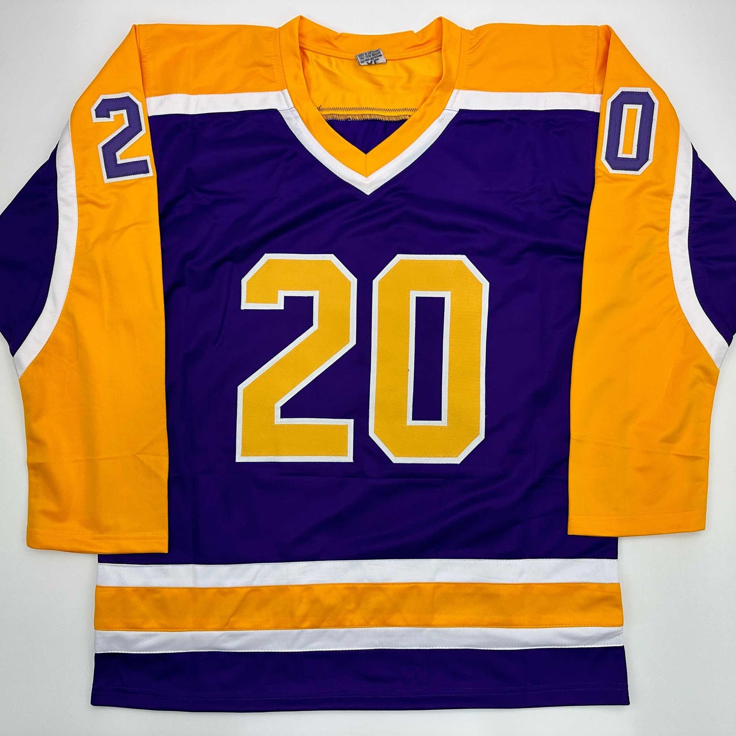 Purple Los Angeles Kings hockey jersey number 20 displayed flat with gold and orange sleeves and white trim.