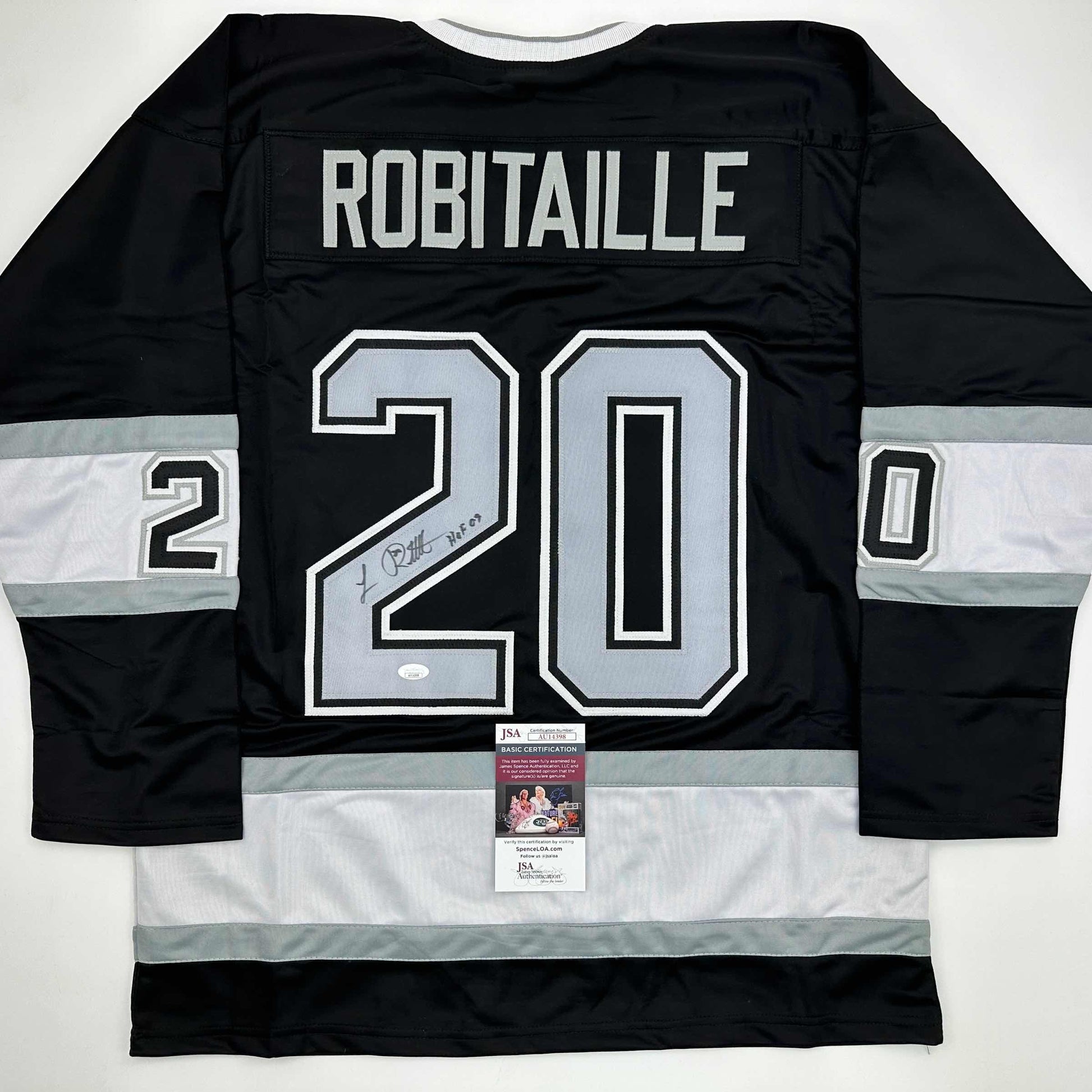 Back view of signed black and white hockey jersey #20 with ROBITAILLE nameplate and JSA authentication certificate visible.