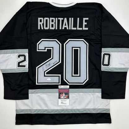 Back view of signed black and white hockey jersey #20 with ROBITAILLE nameplate and JSA authentication certificate visible.