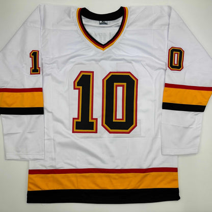 White hockey jersey with number 10 in black and red lettering, displayed flat against gray background showing front view.