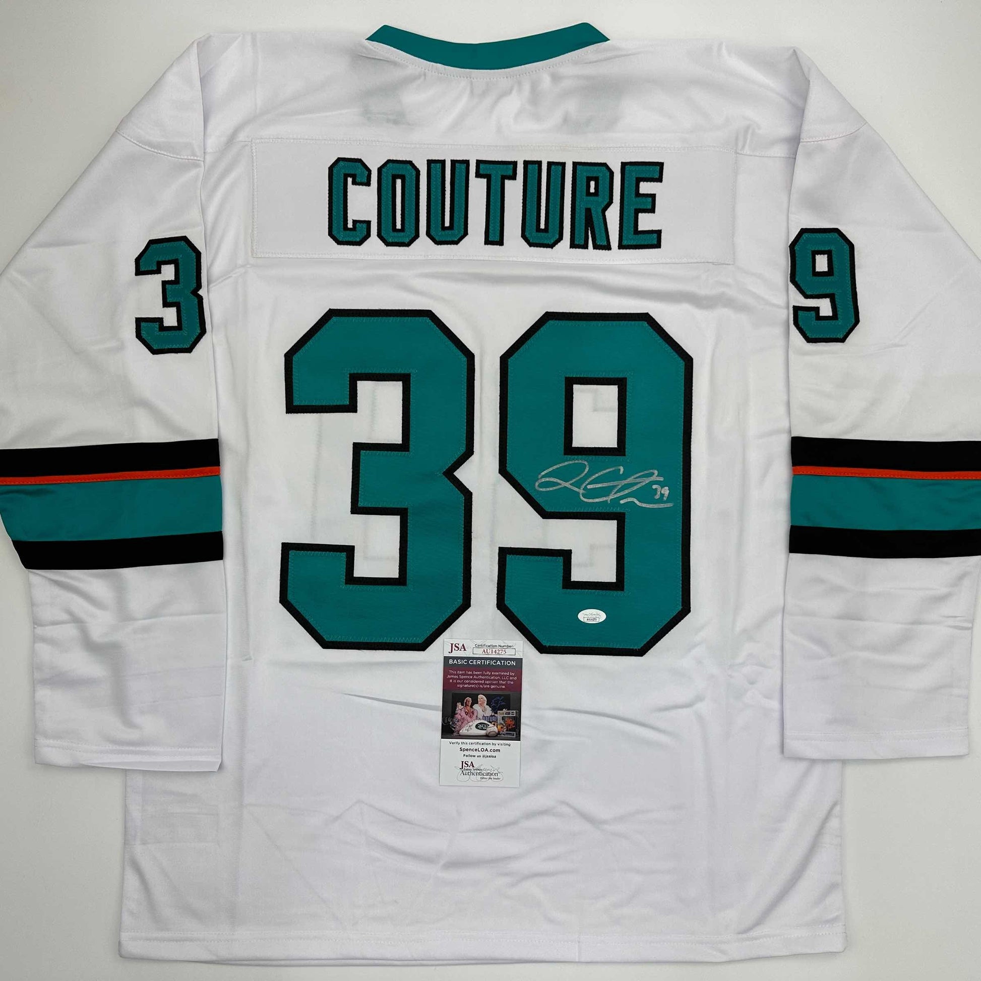 Back view of white hockey jersey with teal and black trim, displaying "COUTURE" and number 39 with signature and JSA authentication label.