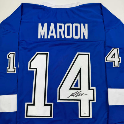 Back view of blue hockey jersey with white "MAROON" nameplate and number 14, featuring an autographed signature on the numbers.