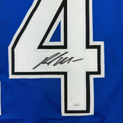 Close-up of white number 4 on blue hockey jersey with black outline and player autograph signature.