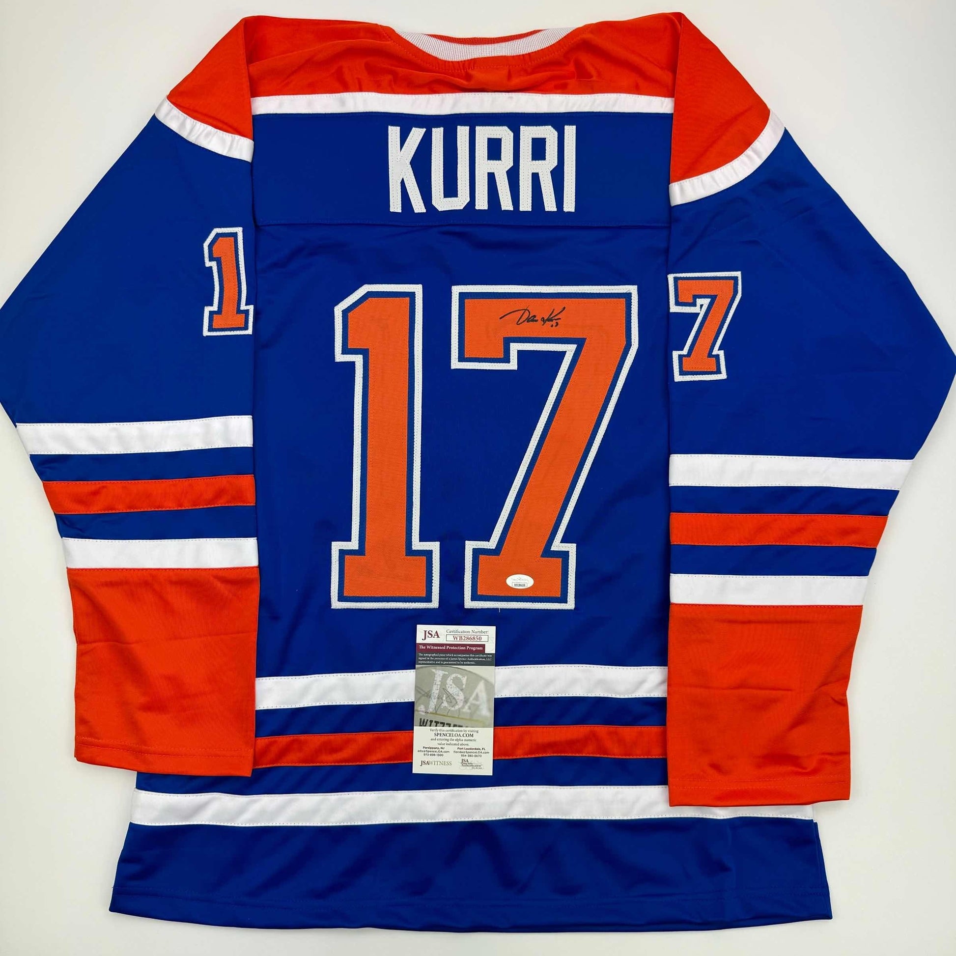 Signed blue Edmonton Oilers hockey jersey number 17 with "KURRI" nameplate displayed flat, back view showing JSA authentication certificate.