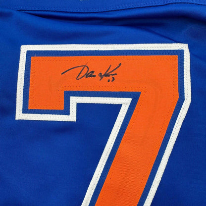 Close-up of number 7 on blue jersey with orange fabric and handwritten signature above the numeral.
