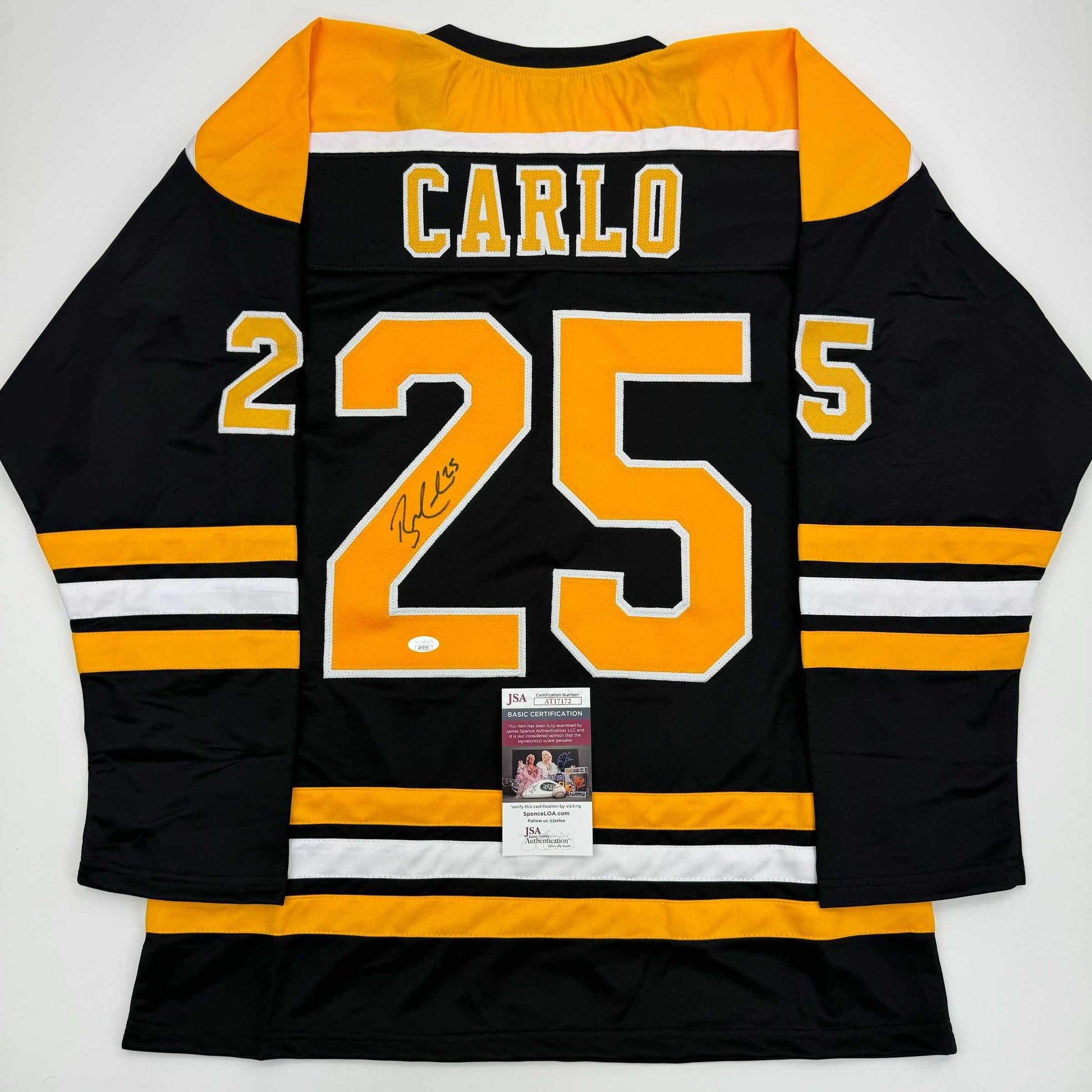 Back view of black and gold Boston Bruins hockey jersey number 25 with "Carlo" nameplate and signature, JSA authentication certificate visible.