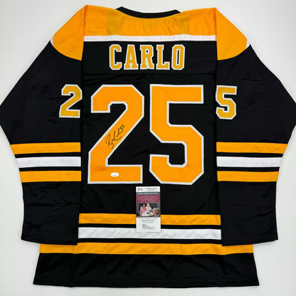 Back view of black and gold Boston Bruins hockey jersey number 25 with "Carlo" nameplate and signature, JSA authentication certificate visible.