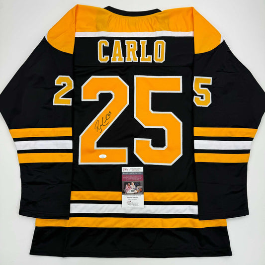 Back view of black and gold Boston Bruins hockey jersey number 25 with "Carlo" nameplate and signature, JSA authentication certificate visible.