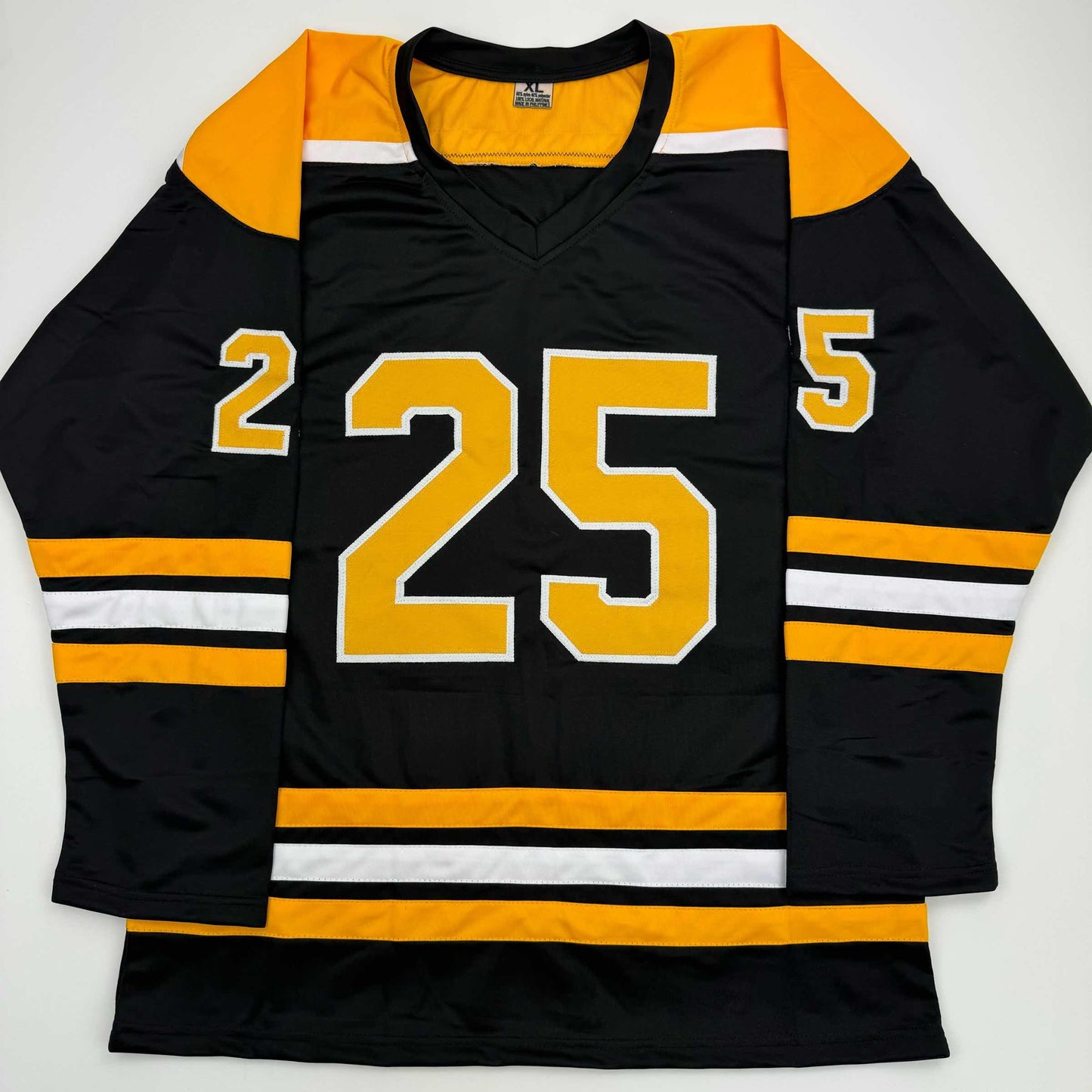 Black and gold hockey jersey with number 25 displayed flat against white background, front view showing V-neck collar and striped sleeves.
