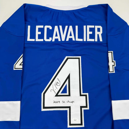 Back view of blue hockey jersey with white "LECAVALIER" nameplate and number 4, autographed with "2004 SC champs" inscription.