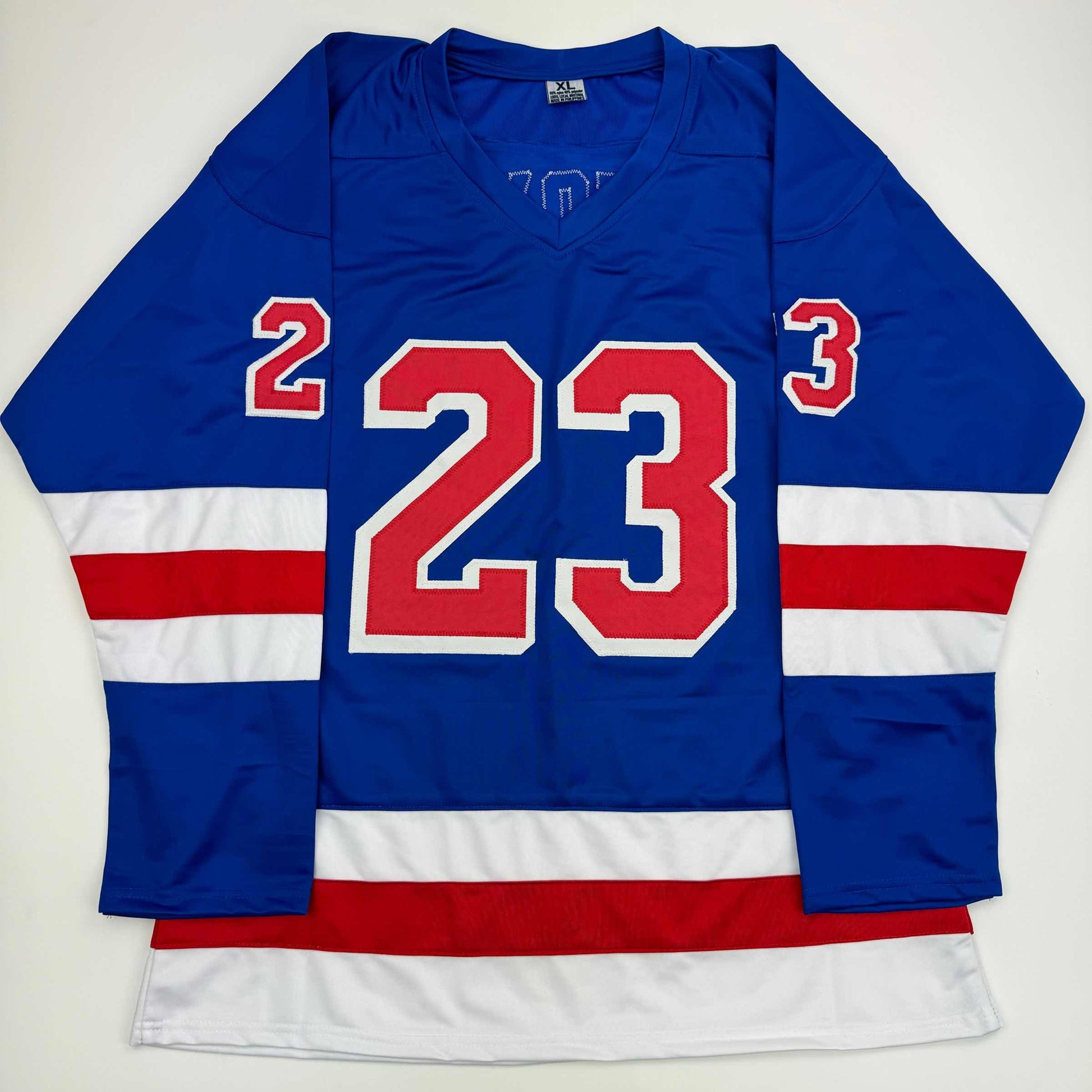 Blue New York Rangers hockey jersey with red number 23 displayed flat against white background, showing front view with striped sleeves.