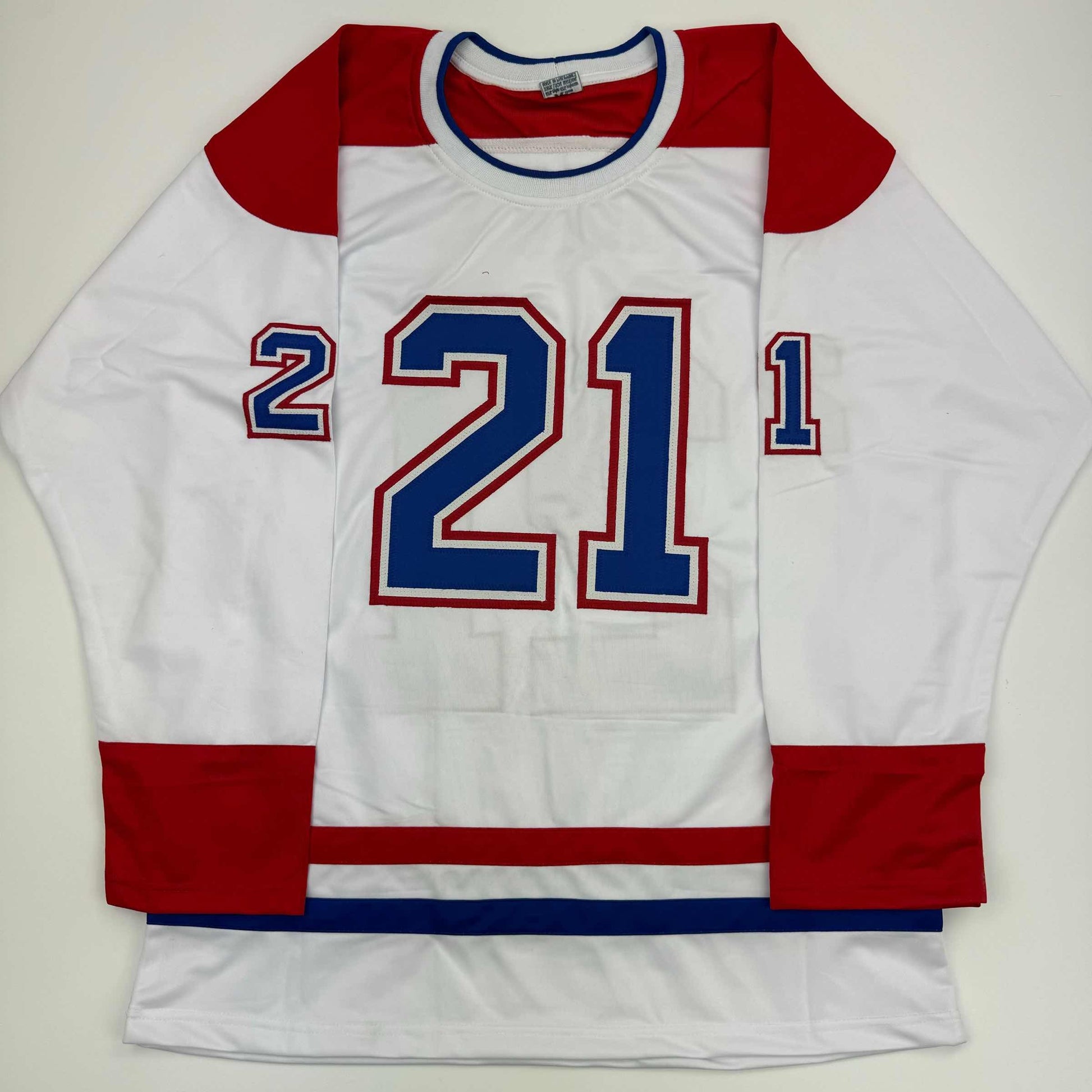 White Montreal hockey jersey with red sleeves and blue trim displaying number 21 on front, laid flat.