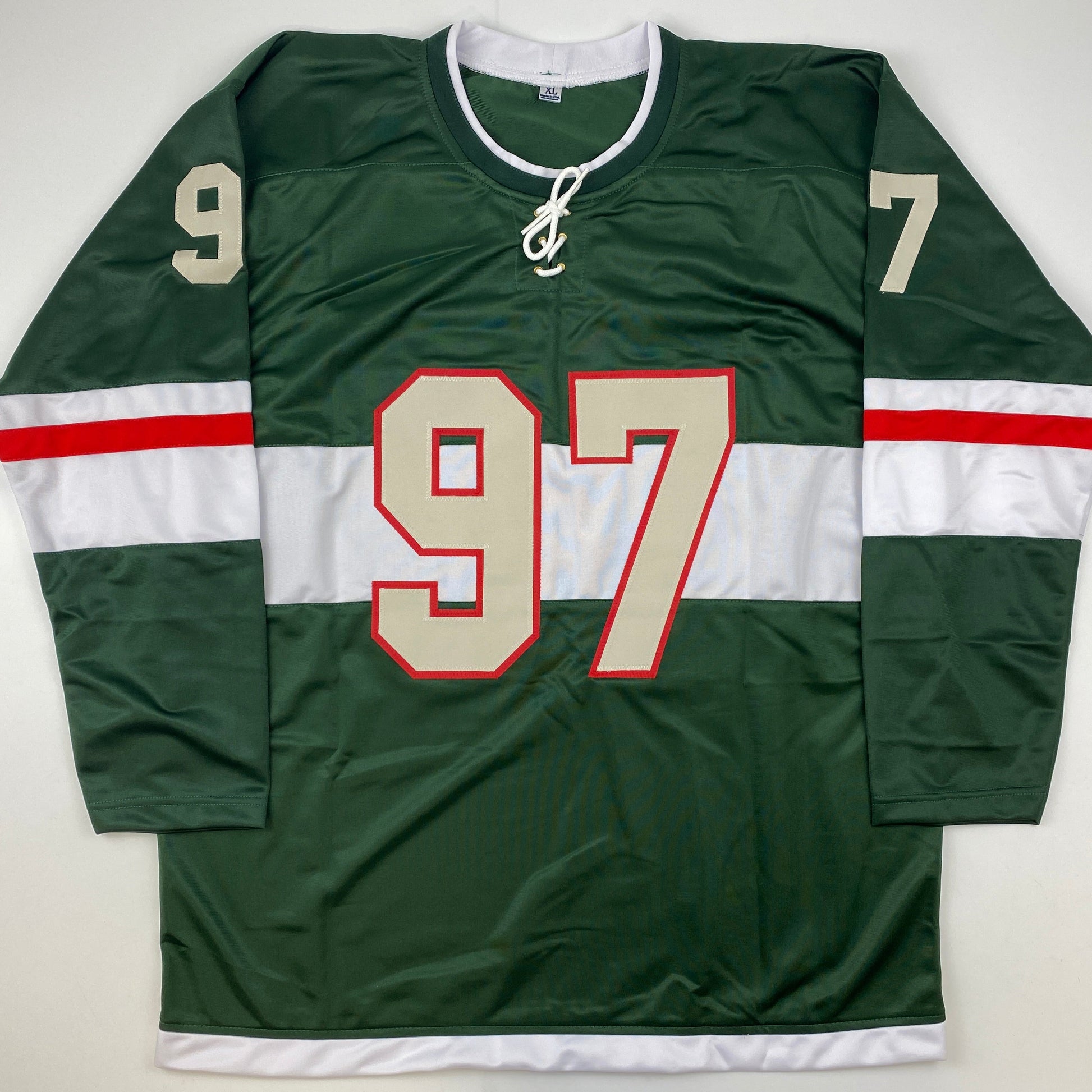 Front view of green, white, and red hockey jersey with cream-colored number 97 and shoulder numbers 9 and 7.