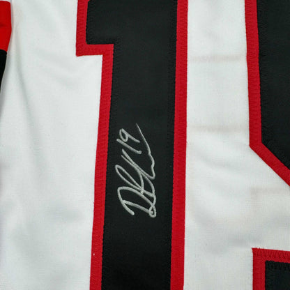 Close-up of signed Drake Batherson Ottawa hockey jersey showing red and white striped fabric with black vertical stripe and gray autograph.