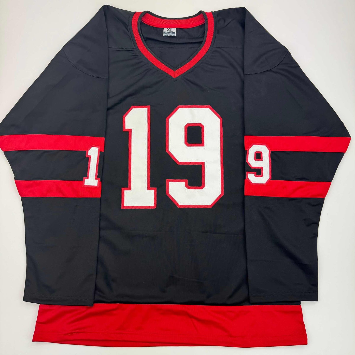 Black and red hockey jersey with white number 19 and red striped sleeves, displayed flat on white background.