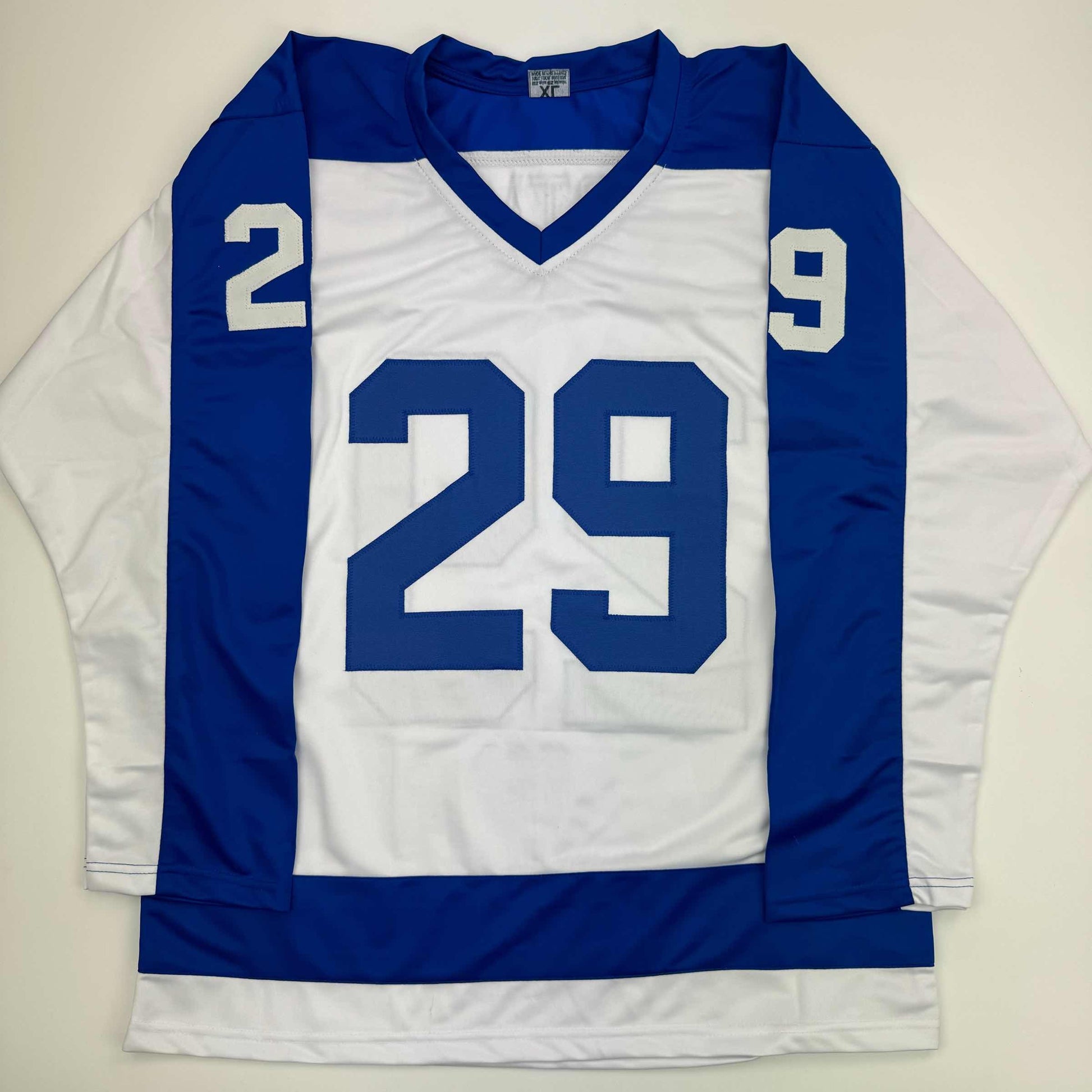 Blue and white hockey jersey with number 29 displayed flat against neutral background, front view.