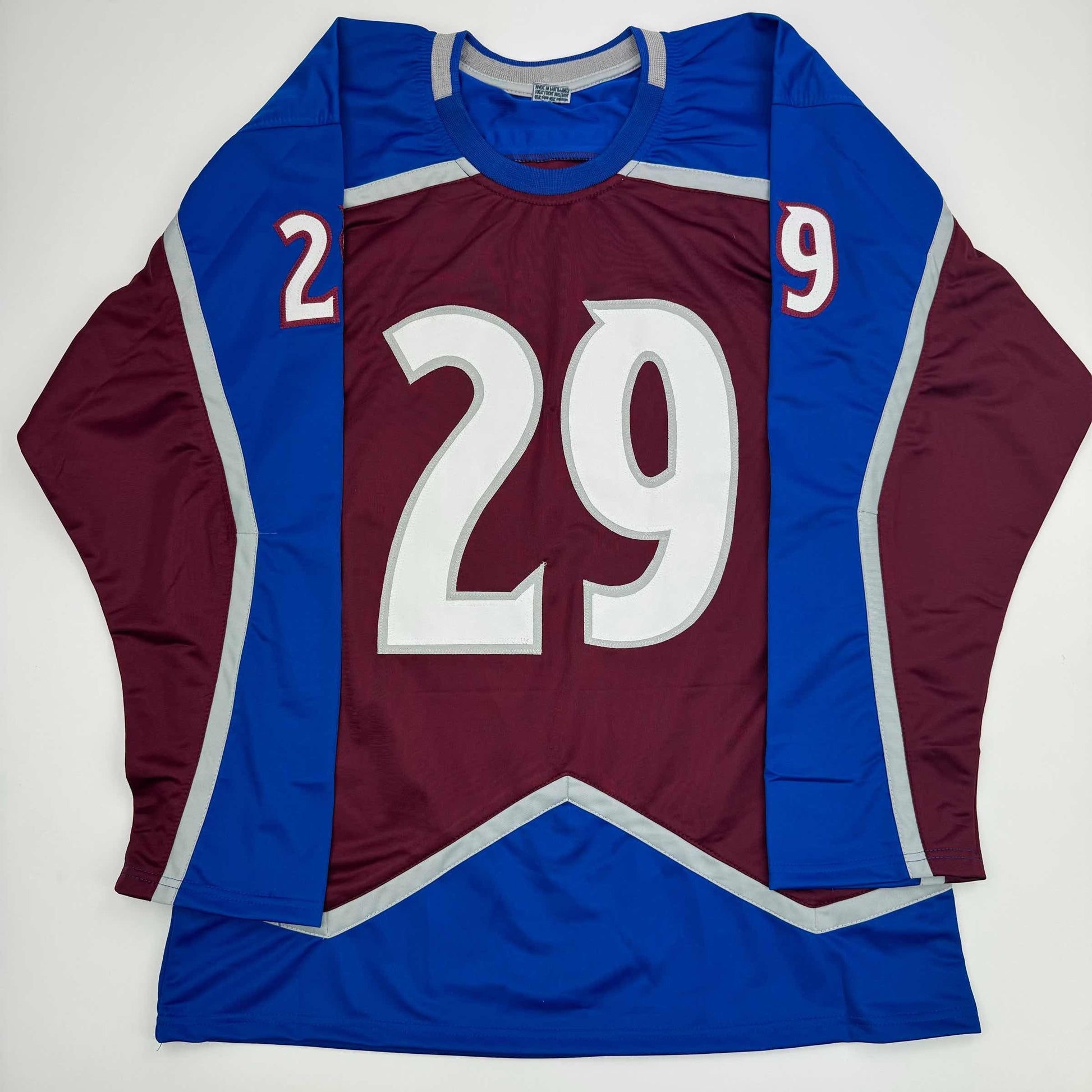 Front flat lay of burgundy and blue NHL hockey jersey with large white number 29 and shoulder numbers 2 and 9.