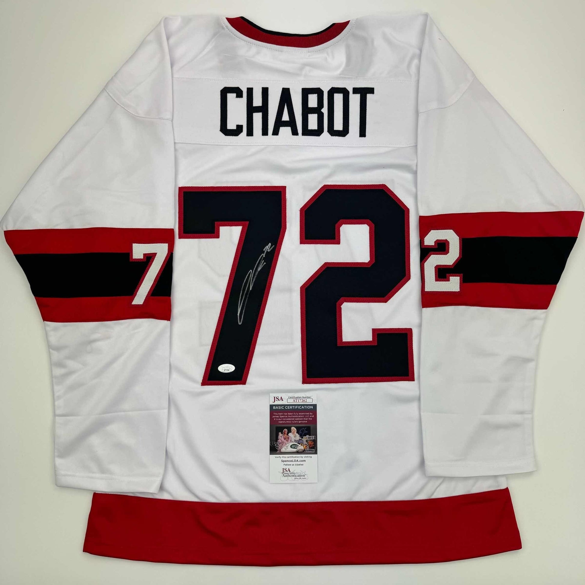 Flat lay of white hockey jersey with red and black stripes, displaying "CHABOT 72" with autographed number and JSA certification sticker.