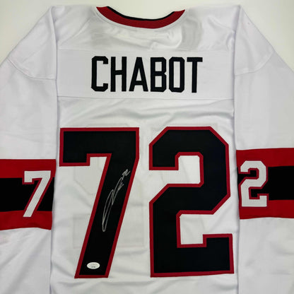 White hockey jersey with "CHABOT" printed across chest and number 72 with signature, red and black trim visible.