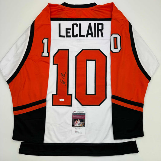 Back view of signed orange, white, and black Philadelphia Flyers hockey jersey number 10 with LeClair nameplate and JSA authentication certificate.