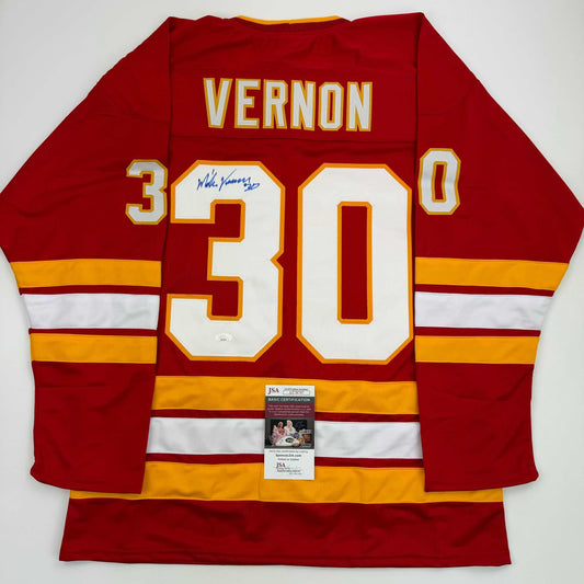 Red Calgary Flames hockey jersey with number 30, "VERNON" nameplate, autographed signature, and JSA certification sticker, displayed flat against white background.