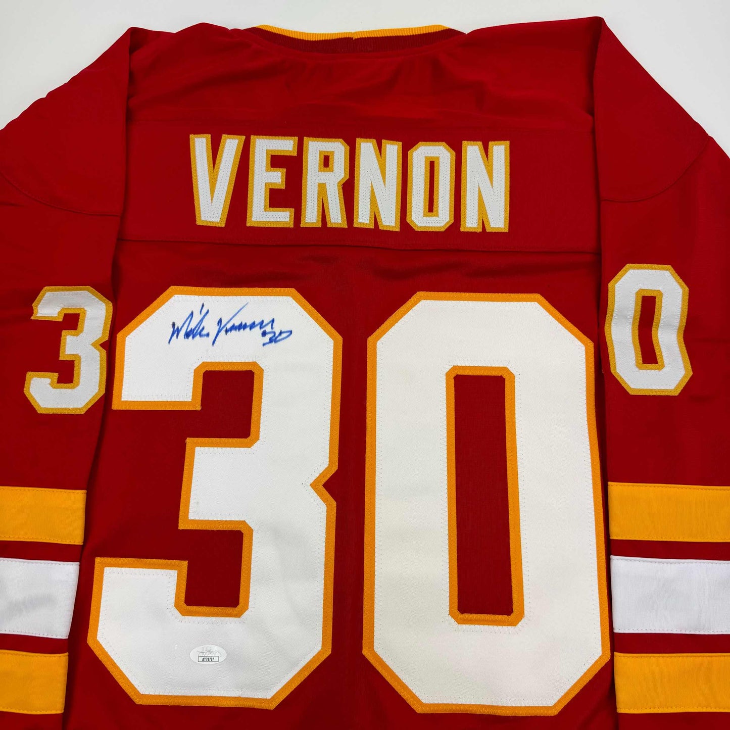 Red Calgary Flames hockey jersey with "VERNON" and number "30" displayed, featuring an autographed signature on the chest.